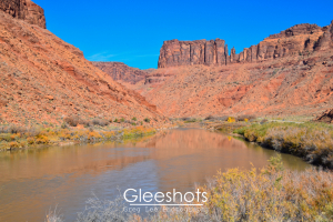 The Colorado River flows between red rock cliffs along Route 128 in Moab Utah.  Landscape Photography Print for Sale.