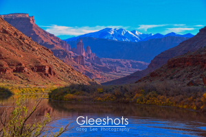 The red rock Fisher Towers near Moab are pictured here at sunset, with the Colorado River in the foreground and the snow-capped La Sal Mountains in the background.  Utah Fine Art Landscape Photography for Sale.