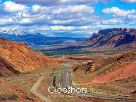 A dramatic view of Moab from above, as seen looking down from Arches National Park, showcasing the  varied colored rock topography of the area.  Utah Fine Art Landscape Photography for Sale.